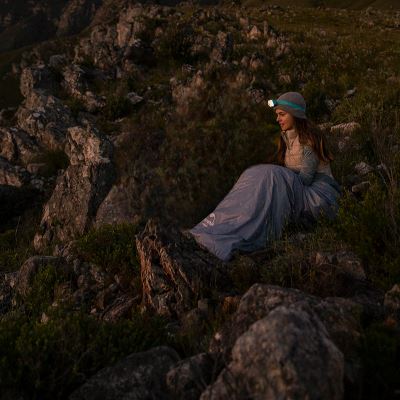 femme-assise-sac-de-couchage-lampe-frontale