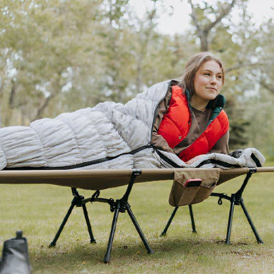 femme-couchee-lit-de-camp-exterieur