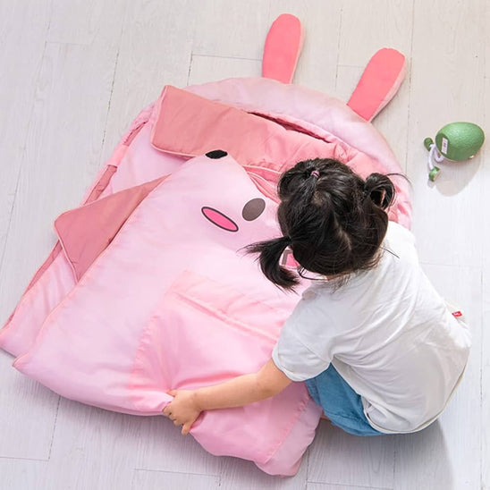 fillette-installe-sac-couchage-lapin-rose