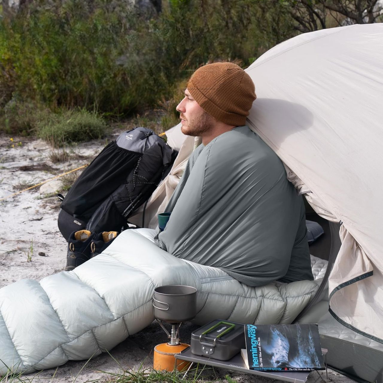 homme-assis-sac-couchage-tente